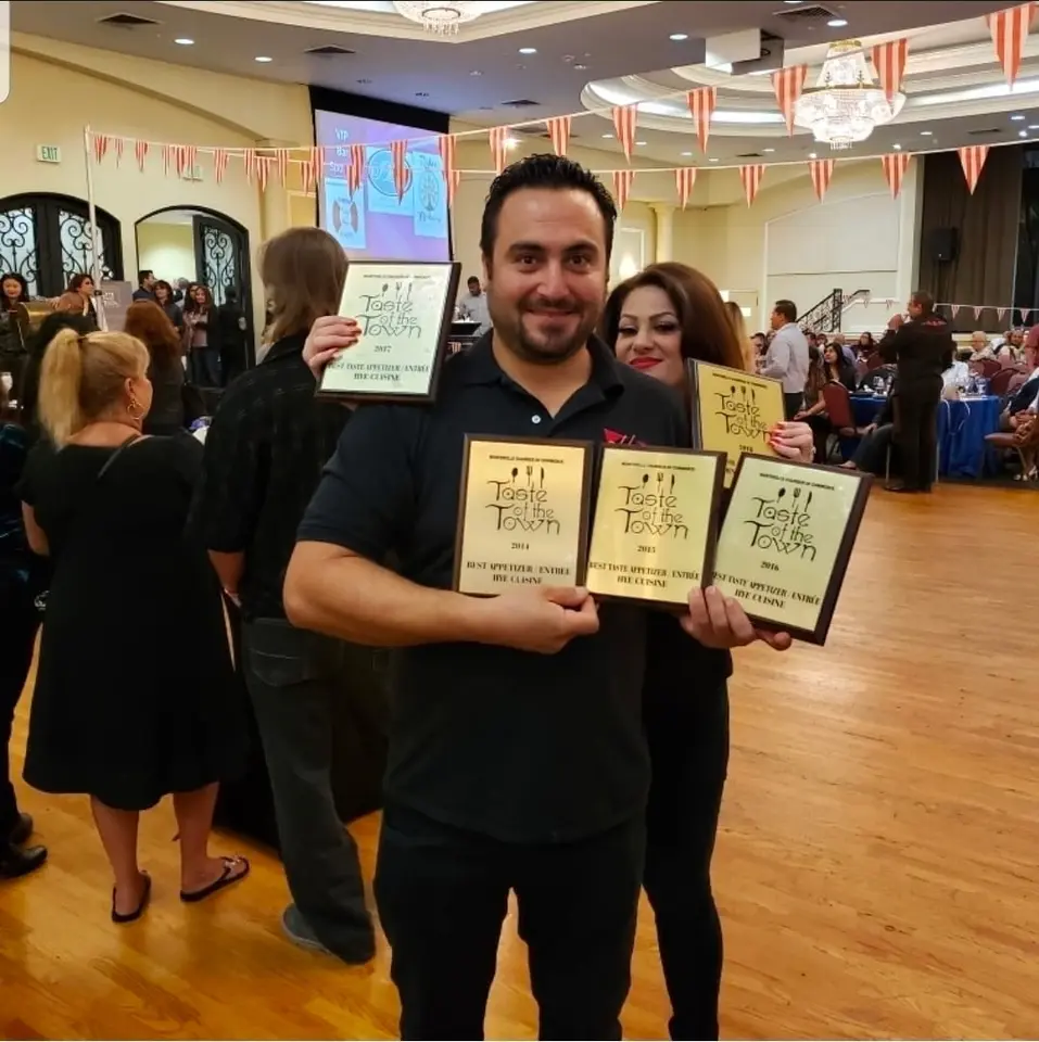 Chef Pat holding his Taste of Town award plaques